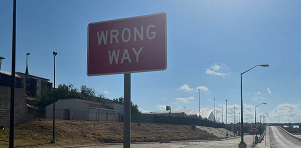 Photo of a "Wrong Way" sign under the international bridge where migrants in MPP proceeding enter the U.S. for their hearings