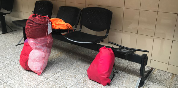 Photo of a family's baggage piled on a bench at an airport in Guatemala