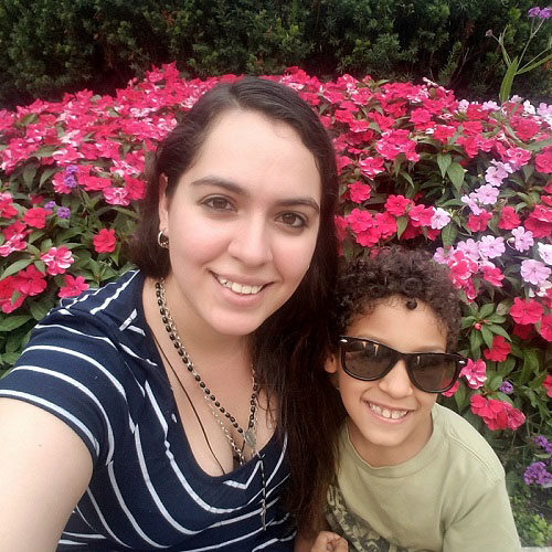 Young mother with her son with bright pink flowers in the background