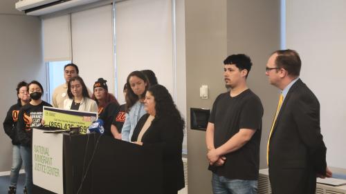 A group of people gather behind a podium at a press conference