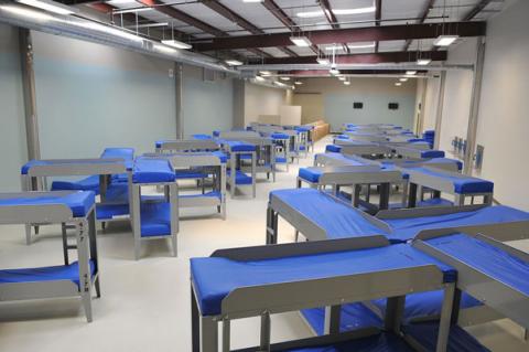 Photo of a Farmville detention center dormitory with rows of bunk beds with blue mattressses