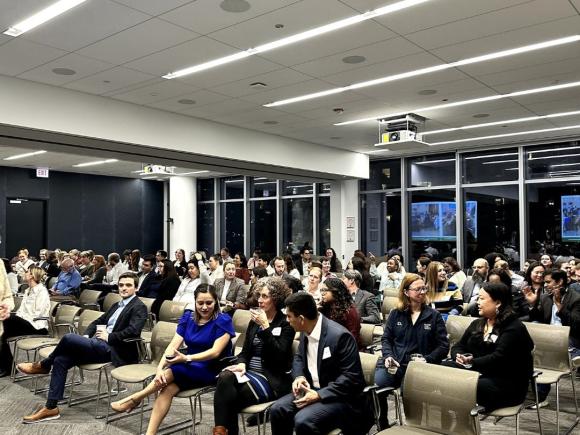 A group of attorneys and other staff members sitting in a large conference room.