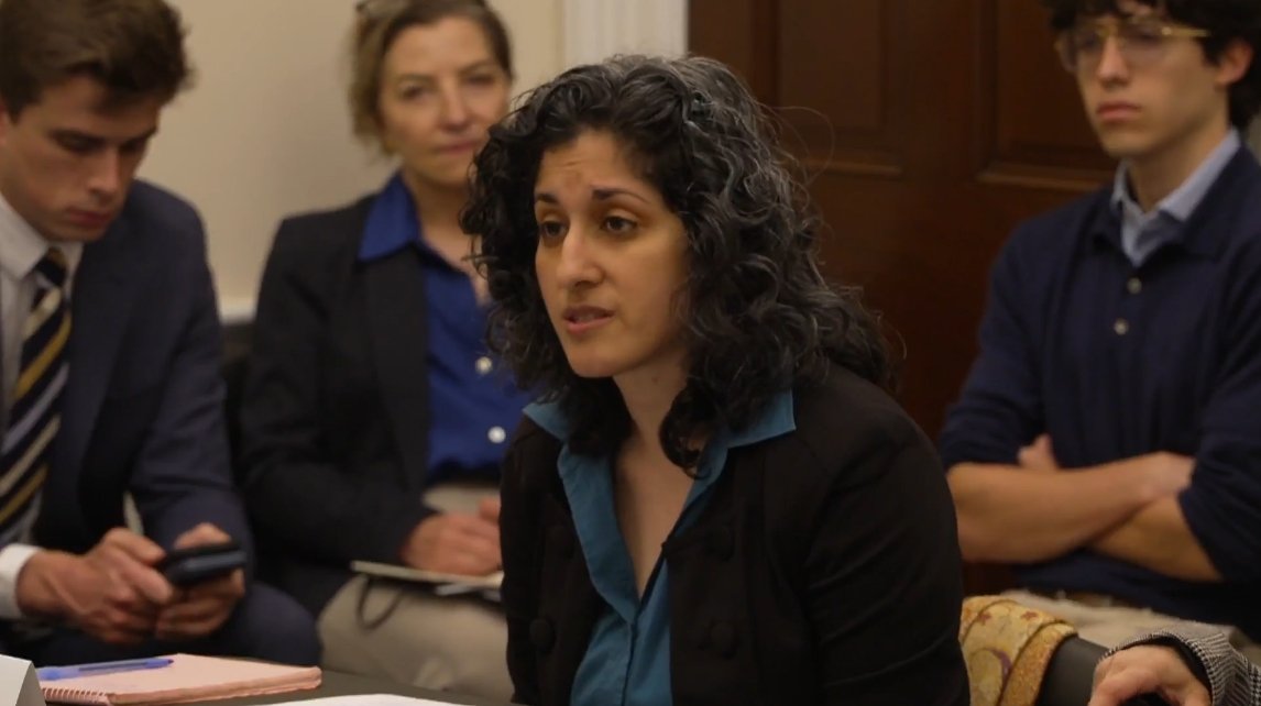 Woman wearing business attire testifies at a Congressional hearing